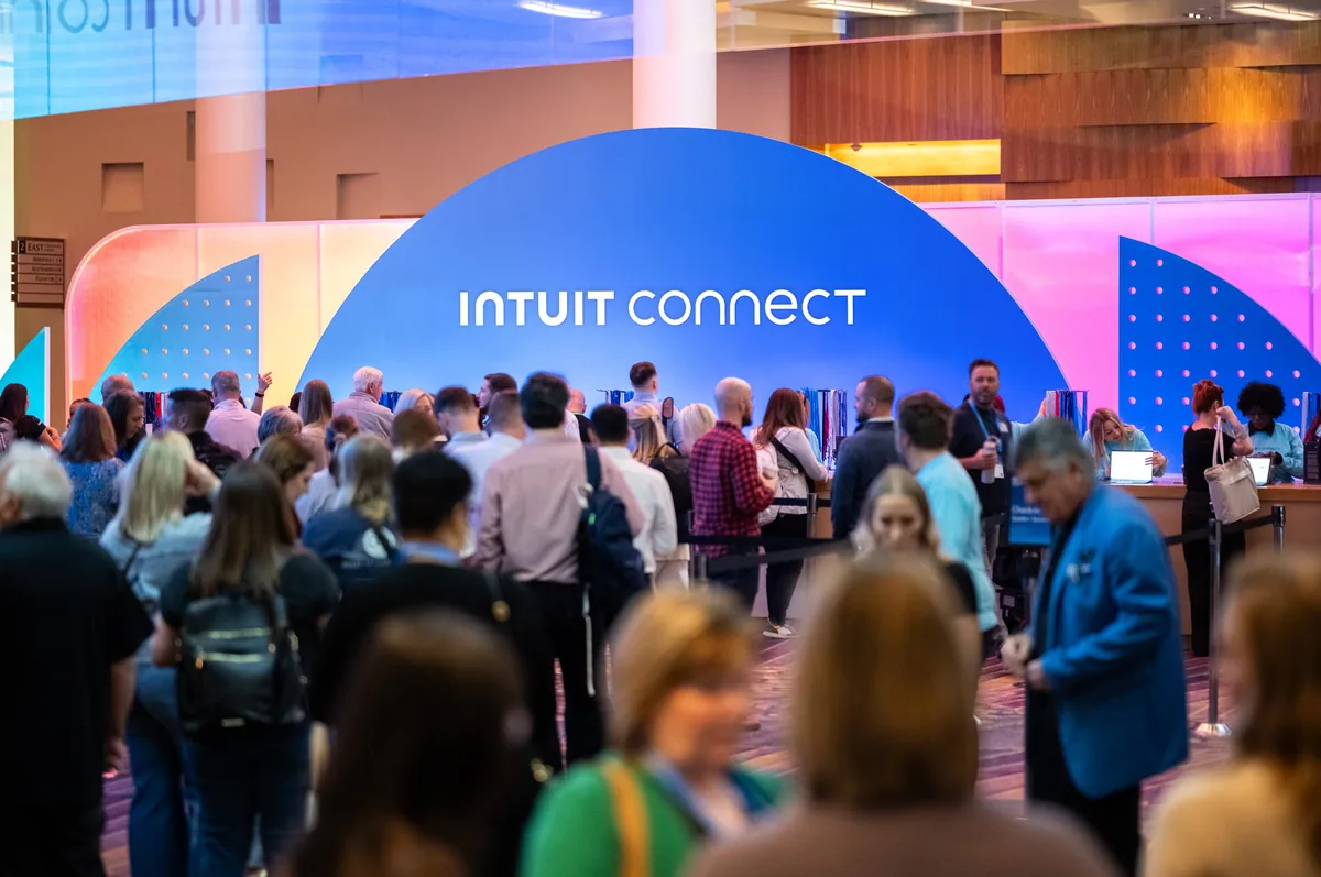 Attendees gathering beneath the Intuit Connect registration arch