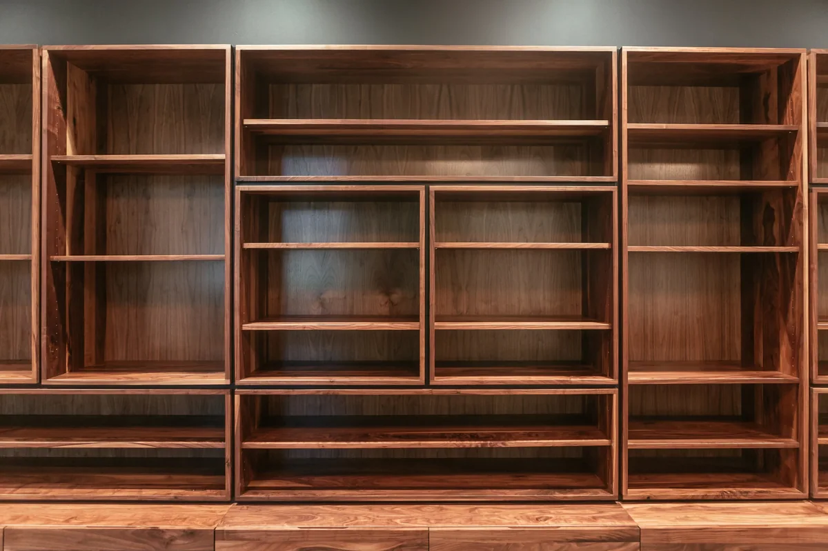 The long wall of walnut shelving