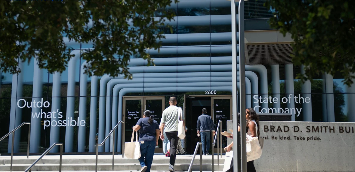Employees walking into the building, with Outdo what’s possible on the facade